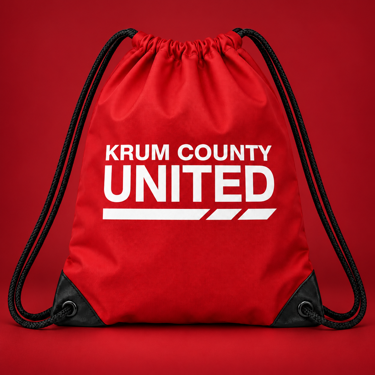 Red drawstring bag with black cords and white Krum County United Matchday lettering on the front.